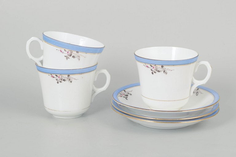 Carlstad, Europe. Porcelain set of three large coffee cups with matching saucers with blue rim and: Carlstad, set of three large coffee cups with matching saucers. Elegant porcelain set with light blue rim and delicate floral decoration. The "Carlstad" model reflects a classic design language 