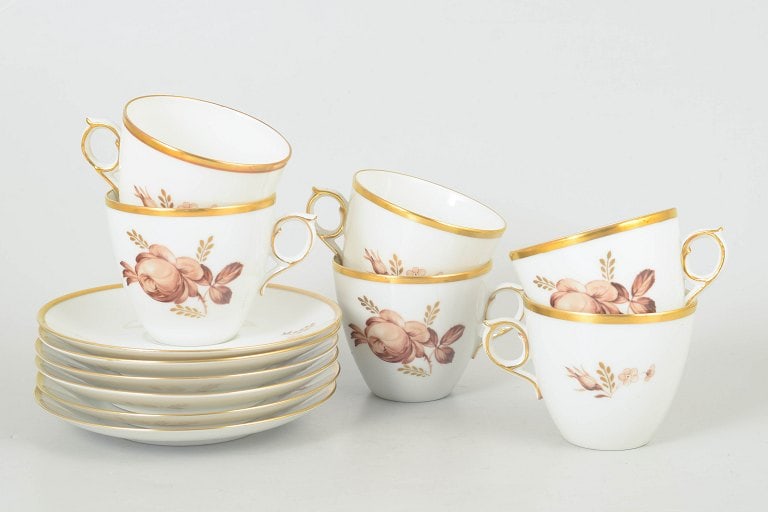 Royal Copenhagen, Denmark. Brown rose, set of six porcelain coffee cups with matching saucers with: Royal Copenhagen brown rose, set of six coffee cups with matching saucers. Elegant white porcelain service decorated with brown floral motif and gilt rim. Model 688/9069. First quality. Origin: Denmar