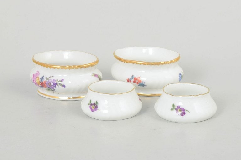 Royal Copenhagen, Denmark. Saxon flower, set of four salt jars with polychrome floral decoration.: Royal Copenhagen Saxon flower, set of four salt jars. Set of four small porcelain salt jars with polychrome floral decoration in the Saxon flower pattern and gilded rims. Varying shapes and sizes. Mod