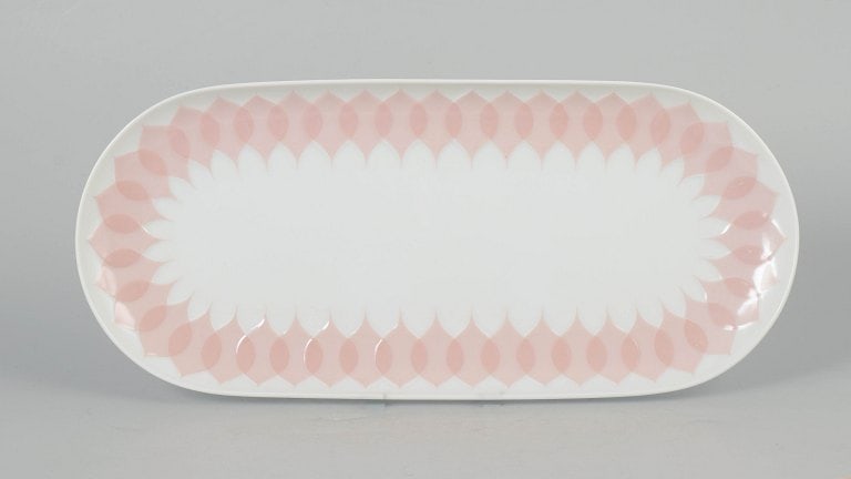 Bjørn Wiinblad for Rosenthal, Germany. Oval porcelain dish with pink "Lotus" pattern.: Bjørn Wiinblad for Rosenthal, oval dish. Decorative oval porcelain dish featuring the distinctive pink "Lotus" pattern along the rim, composed of a repeating petal motif with soft tonal