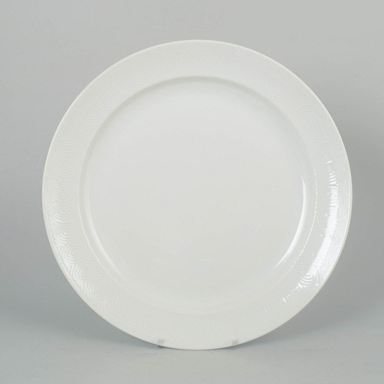 Axel Salto for Royal Copenhagen, Denmark. Porcelain round platter with white glaze and relief: Axel Salto for Royal Copenhagen, round platter. Elegant round porcelain platter with a simple white glaze and subtle relief pattern along the rim. The platter was designed by Axel Salto for Royal Cope