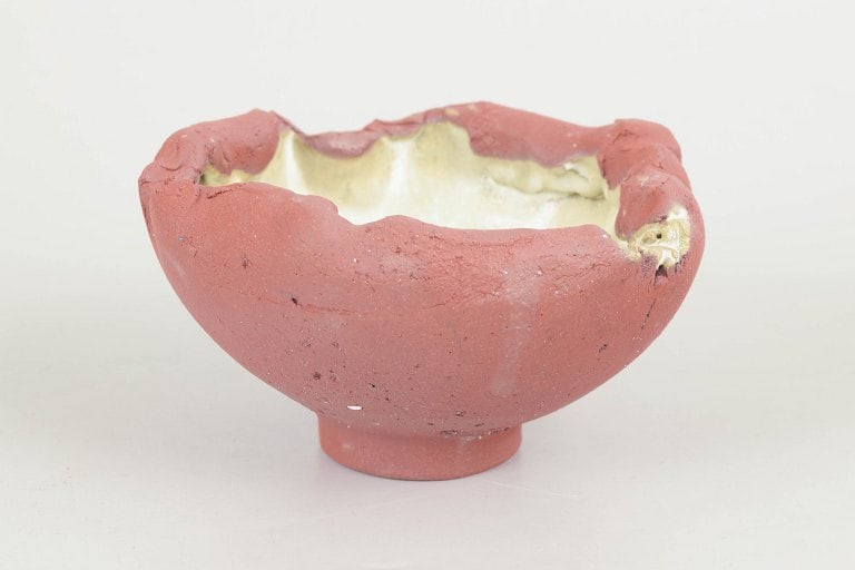 Christina Muff, Danish contemporary ceramicist (b. 1971). Small, one of a kind red stoneware bowl on: Christina Muff, Danish contemporary ceramicist (b. 1971). Small, one of a kind red stoneware bowl on foot. Unglazed on the outside the beautiful red clay contrasts the interior which is glazed in a