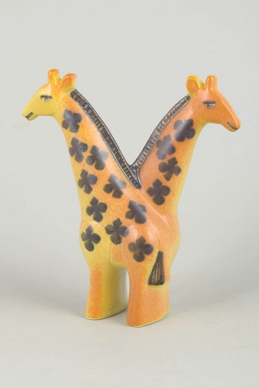 Lisa Larsson for Gustavsberg, Sweden. Stoneware double giraffe figurine with floral motifs. Approx.: Lisa Larsson for Gustavsberg, double giraffe figurine. Stylised stoneware figure with two conjoined giraffes, decorated with hand-painted floral motifs and warm yellow and orange glaze tones. The desi