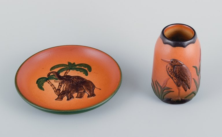 Ipsens Enke, ceramic vase and a ceramic dish. Malibu and elephant motif.: Ipsens Enke, ceramic vase and a ceramic dish. Malibu and elephant motif. Glaze in orange-green shades. Approx. 1920/30s. In perfect condition. Marked. Model numbers. 749 and 7. Vase: H 11.5 x D 7.0