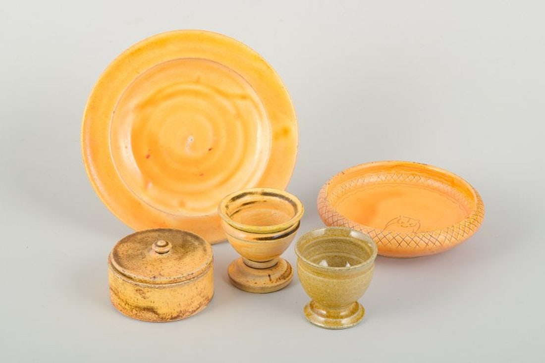 Kähler, Denmark. Ceramic collection with uranium glaze. 1930s/40s.: Kähler ceramic collection in uranium glaze. Five pieces consisting of a plate, a bowl with incised pattern and motif of a raccoon, a round lidded box, and two egg cups. Executed in varying shades