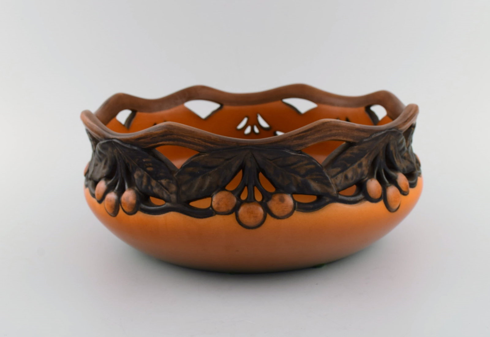 Ipsen's, Denmark. Large bowl in openwork ceramics with hand-painted leaves and berries. 1920s / 30s.: Ipsen's, Denmark. Large bowl in openwork ceramics with hand-painted leaves and berries. 1920s / 30s. Model number 697. Measures: 28 x 12 cm. In excellent condition. Stamped. Reserve: $238.00