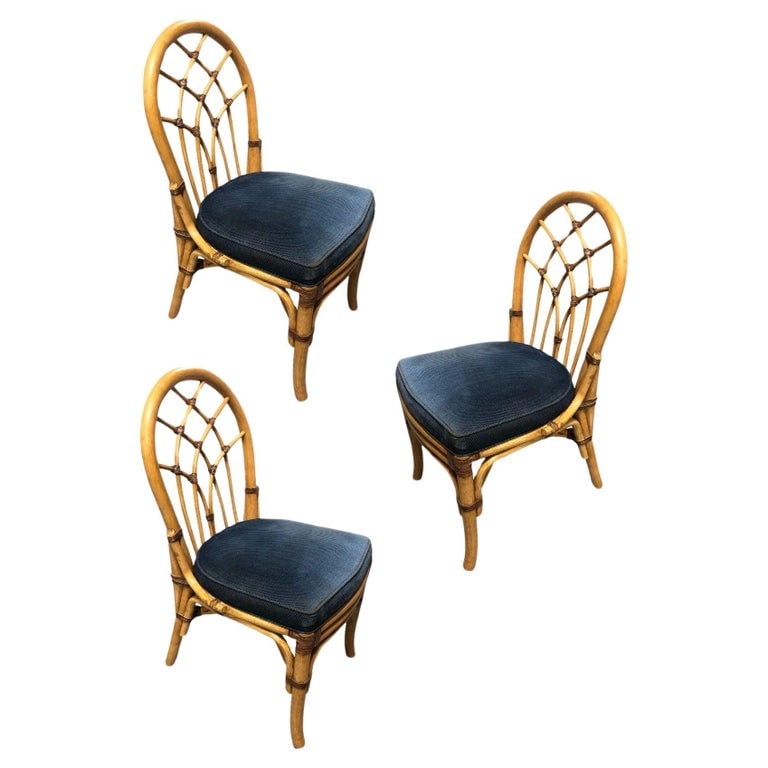 Restored Rattan Dining Chairs with Cathedral Back: These beautifully restored Paul Frankl-inspired Rattan Dining Chairs with Cathedral patterned Back in woven reed rattan. Adorned in a serene dark blue seat cushion, these chairs blend classic rattan i