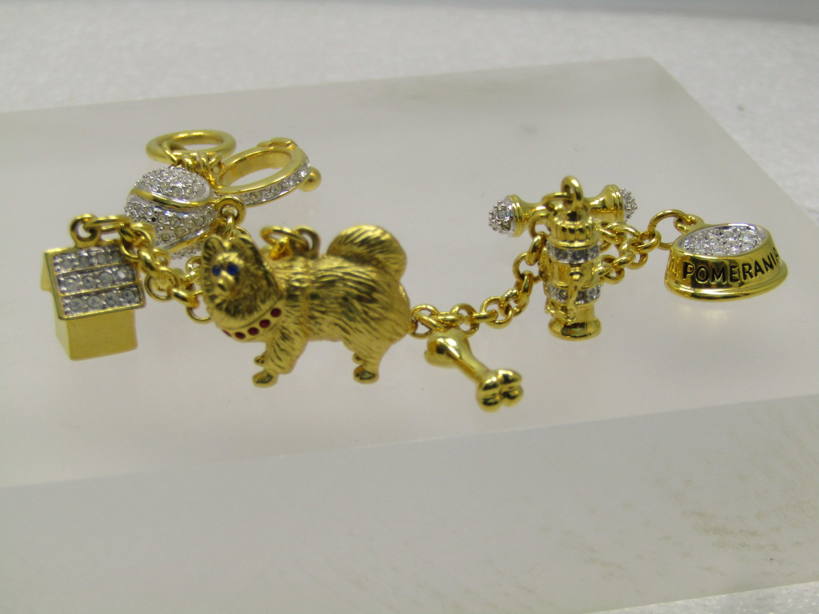 Vintage Pomeran Dog Charm Bracelet, Rhinestones, 7". 1990's, Signed: Title: Vintage Pomeran Dog Charm Bracelet, Rhinestones, 7". 1990's, Signed Description: Vintage Pomeran Dog Charm Bracelet, Rhinestones, 7". 1990's, Signed d/m. This has a toggle clasp with rhinestone