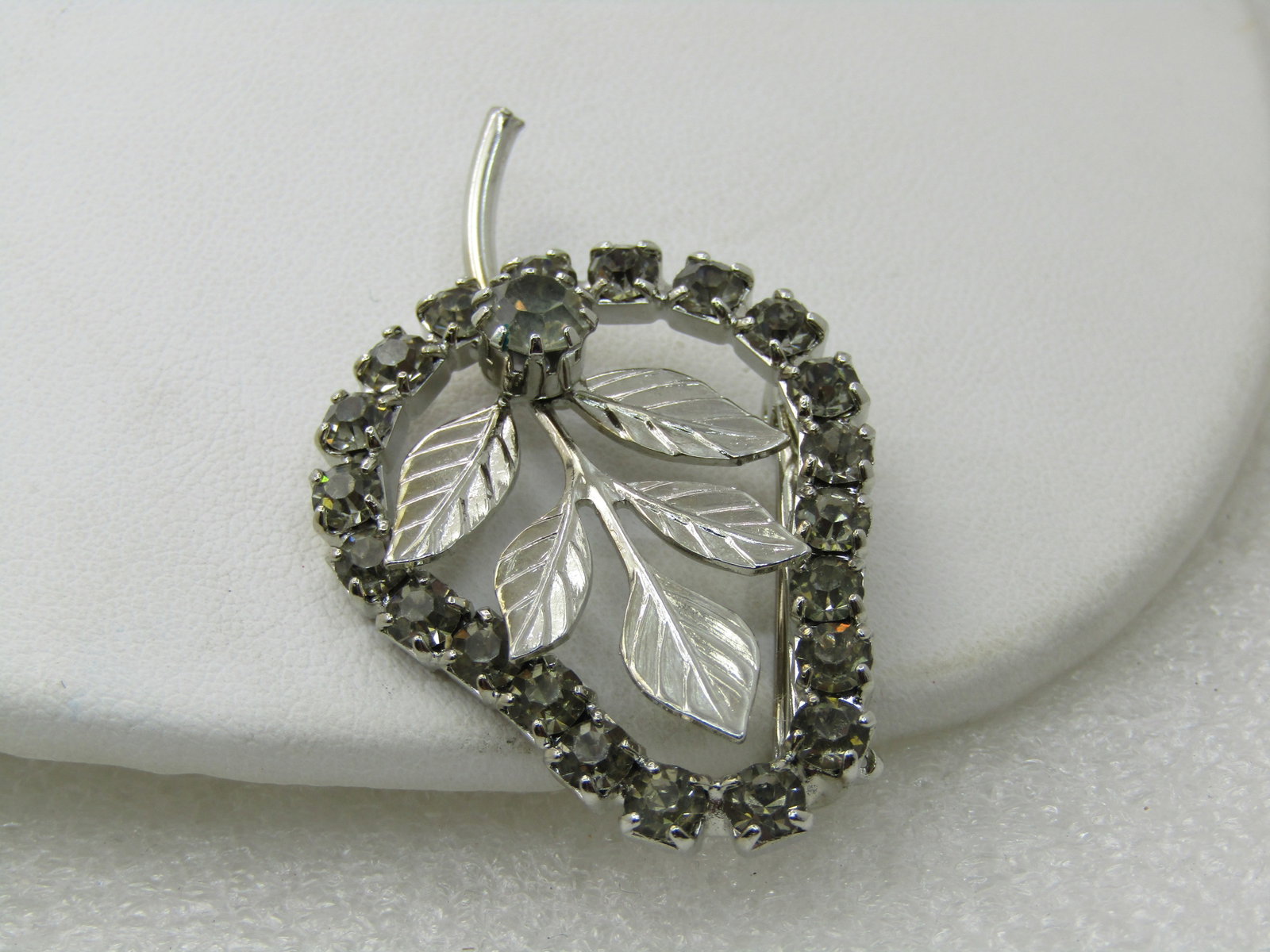 Vintage Rhinestone Pear-Shaped Brooch with Leaves, 1960's, Silver tone, 2": Title: Vintage Rhinestone Pear-Shaped Brooch with Leaves, 1960's, Silver tone, 2" Description: Vintage Rhinestone Pear-Shaped Brooch with Leaves, 1960's, Silver tone, 2". The brooch is framed in smoky
