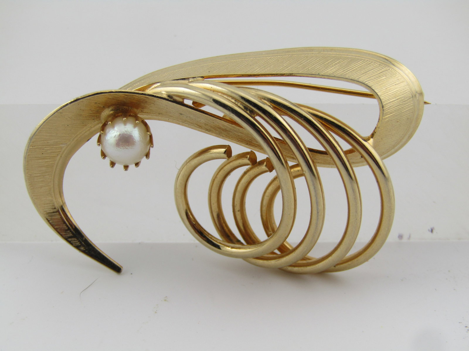 Vintage Gold Tone Coiled Brooch with Pearl, 1960's-1970's: Title: Vintage Gold Tone Coiled Brooch with Pearl, 1960's-1970's Description: Vintage Gold Tone Coiled Brooch with Pearl, 1960's-1970's. Gold tone with four smooth coils goinf off to the side with a