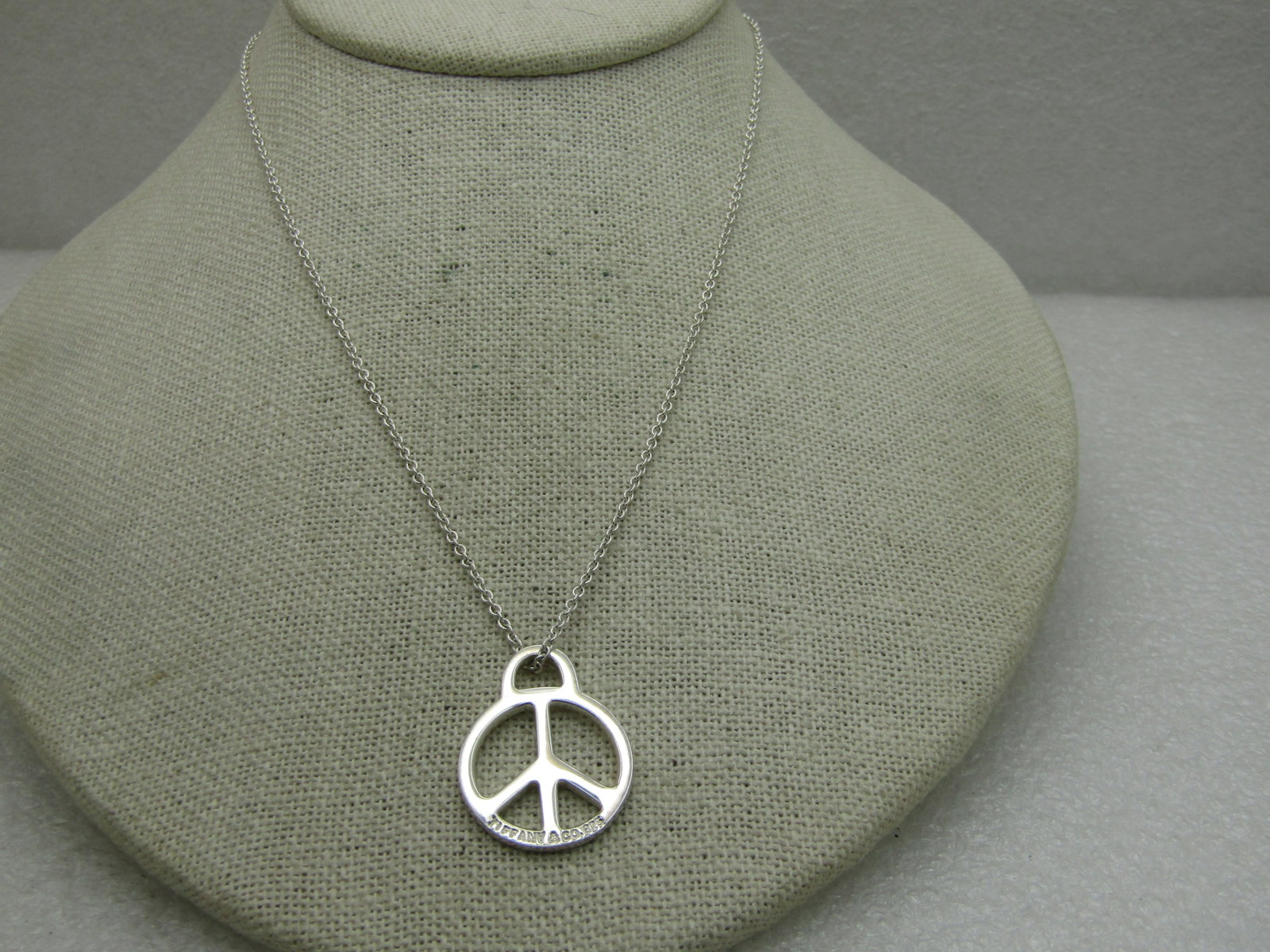 Peace Sign Necklace, 16.5", Silver, Signed: Title: Peace Sign Necklace, 16.5", Silver, Signed Description: Peace Sign Necklace, 16.5", Silver. It has a 1" peace sign pendant and 16.5" alternating link chain. This is signed with a well-known