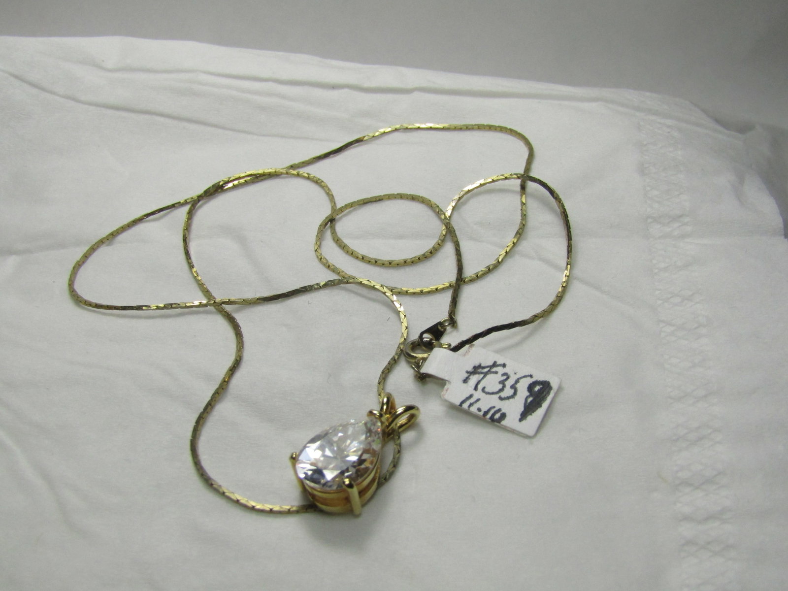 Gold Tone Teardrop Clear CZ Necklace, 23": Title: Gold Tone Teardrop Clear CZ Necklace, 23" Description: Gold Tone Teardrop Clear CZ Necklace, 23", Herringbone Chain 1mm wide. Spring Clasp. The teardrop pendant is appx. 7/8" long and 3/8"