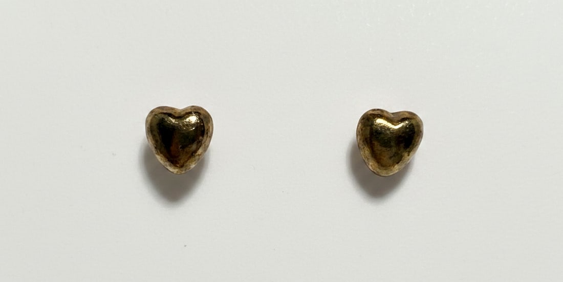Gold-tone Heart Stud Earrings: A charming pair of gold-tone heart-shaped stud earrings, perfect for everyday wear. The earrings feature a simple yet elegant design, making them a versatile addition to any jewelry collection. They