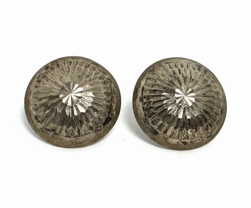 Sterling Silver Faceted Dome Clip-On Earrings: A pair of sterling silver clip-on earrings featuring a faceted dome design. The facets catch the light, creating a shimmering effect. The back is marked "STERLING". Jewelry Type: Earrings Metal: Sterl