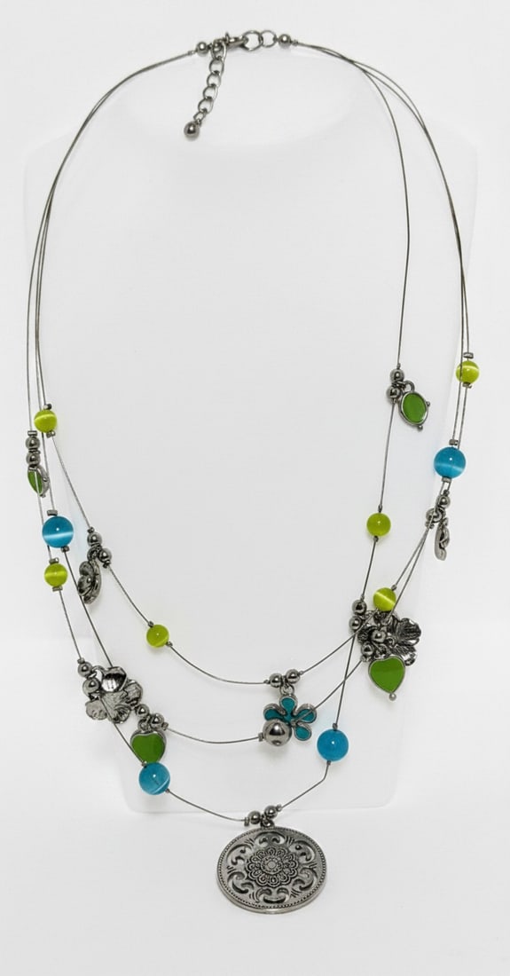 Multi-Strand Beaded Necklace with Filigree Pendant: A multi-strand necklace featuring lime green and turquoise blue spherical and leaf-shaped beads interspersed with silver-tone spacers and floral accents. The necklace culminates in a large circular