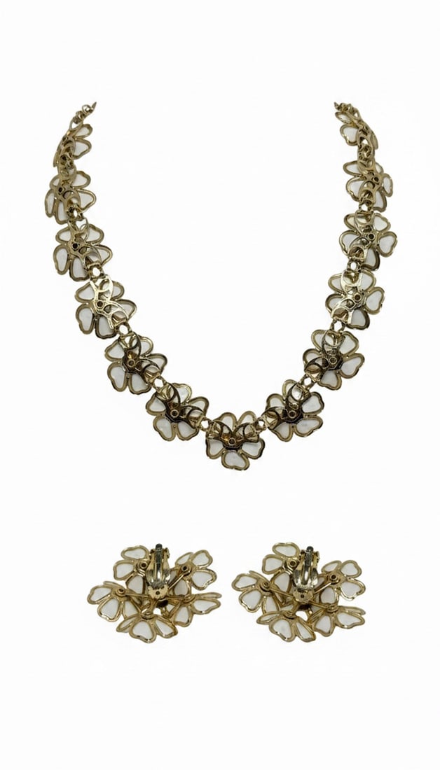 White Enamel and Rhinestone Floral Necklace and Earring Suite: This charming suite features a necklace and a pair of clip-on earrings, each adorned with white enamel floral motifs accented with small, clear rhinestones at their centers. The petals are outlined