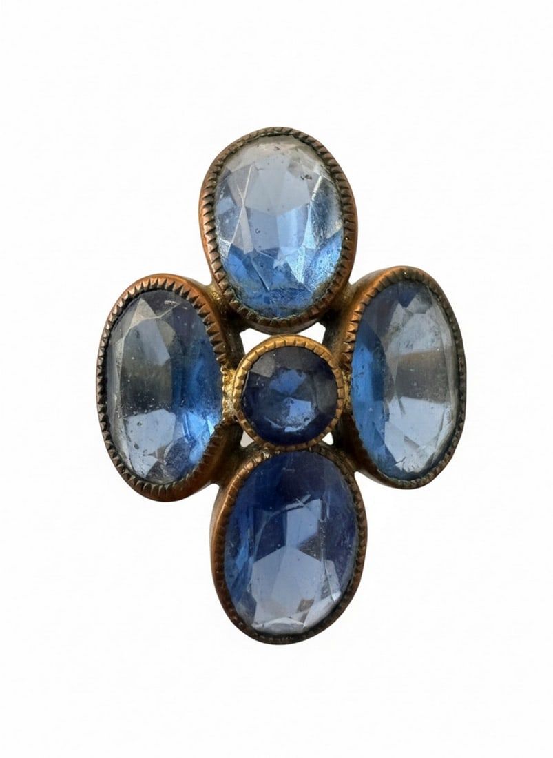 Antique Gold-Toned Ring with Blue Paste Stones: An antique gold-toned ring featuring a cluster of five oval blue paste stones in a floral or quatrefoil arrangement. The setting appears to be an open-backed bezel setting for each stone. The band is