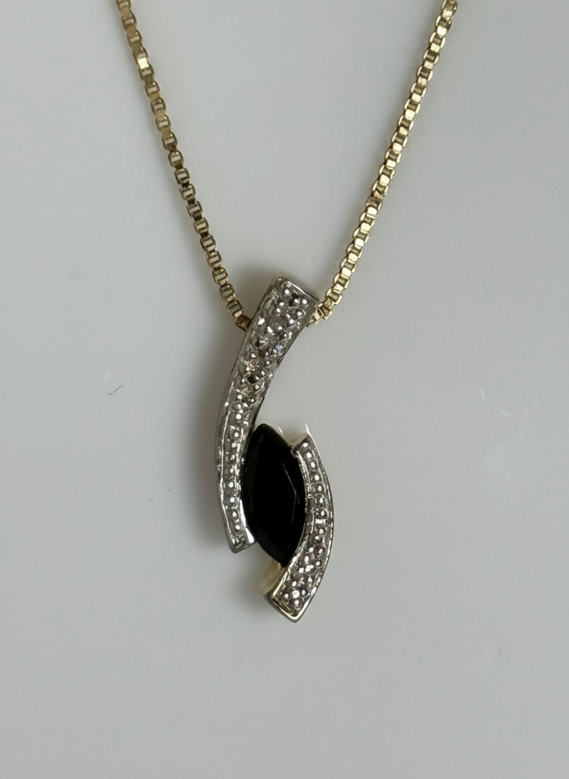 Sterling Silver Gold-Plated Sapphire and Diamond Accent Pendant Necklace: This elegant necklace features a marquise-cut sapphire (likely created) set in a gold-plated sterling silver pendant, accented with small diamond chips or simulated diamonds. The stylized pendant has