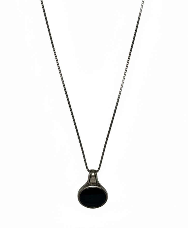 Sterling Silver and Onyx Pendant Necklace: A sterling silver pendant necklace featuring an oval-shaped black onyx cabochon set in a bezel setting. The pendant hangs from a fine sterling silver box chain. The chain is marked "925 INDO" and "18B