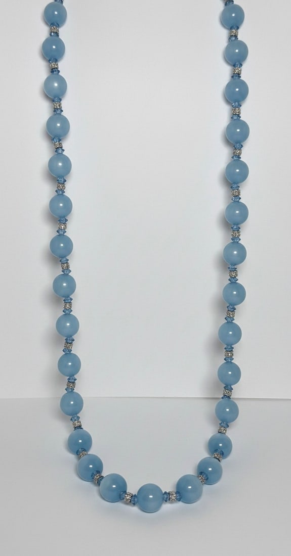 Faux Pearl and Crystal Bead Necklace: This necklace features a single strand of light blue faux pearls, interspersed with smaller clear crystal beads and silver-tone spacers. The faux pearls have a lustrous finish, and the crystals add a