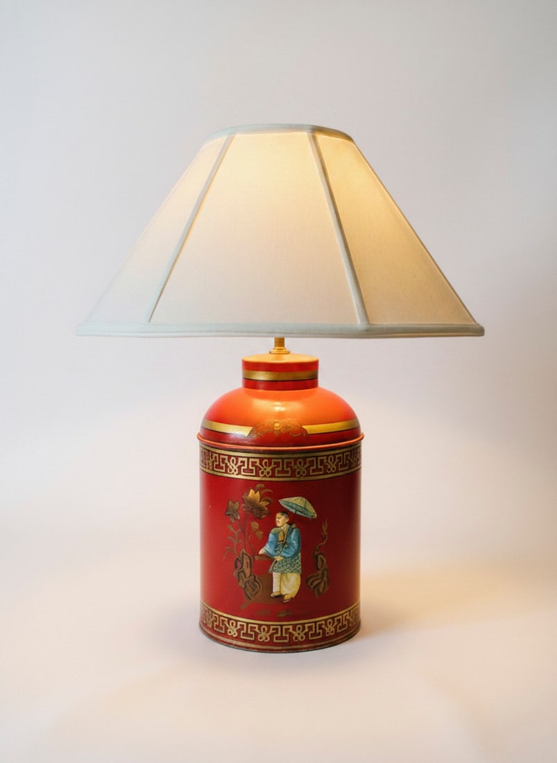 Chinoiserie Red Tea Caddy Lamp: A whimsical lamp crafted from a red tea caddy adorned with Chinoiserie-style hand-painted figures and floral motifs. The tea caddy base features a rich red background with gold borders and intricate