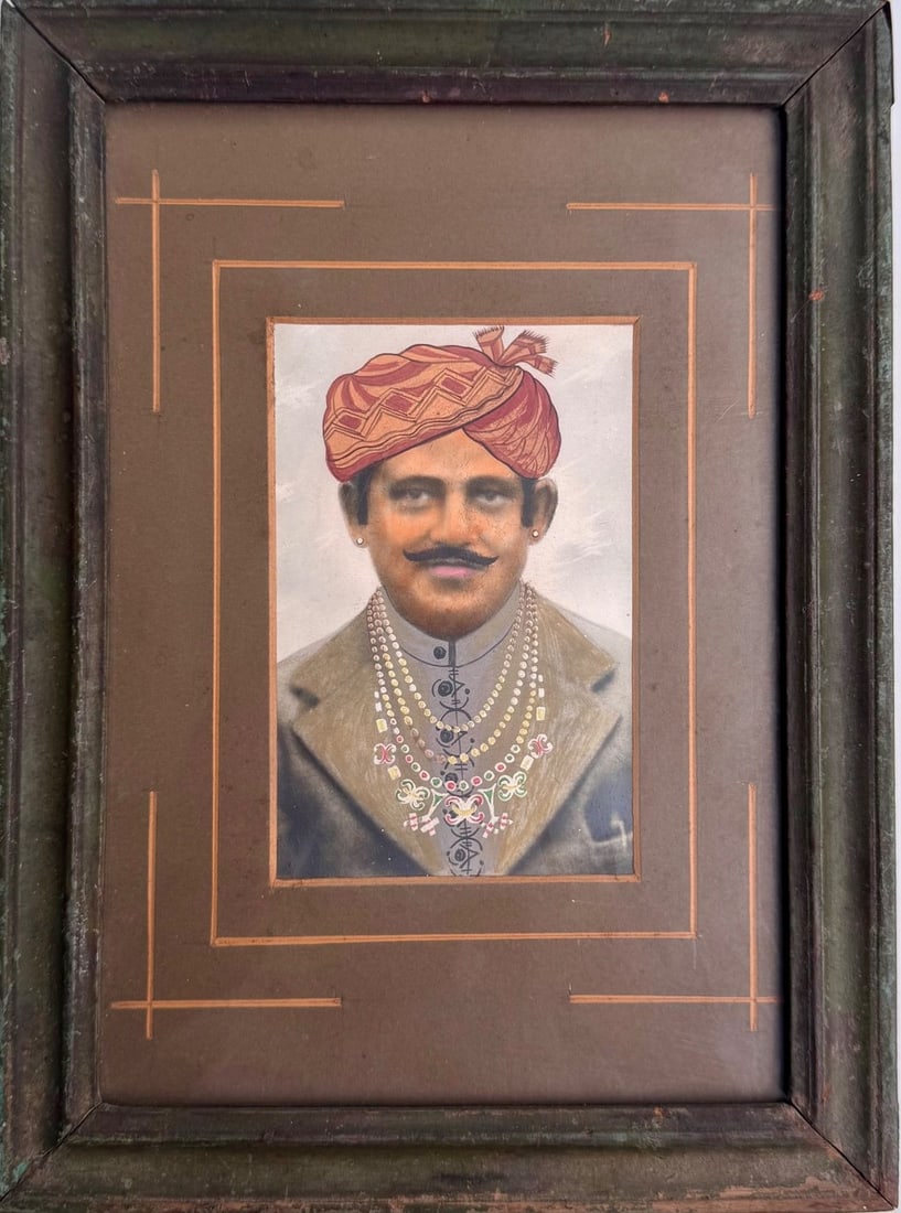 Portrait of a man's Hand-coloured Photograph, c. Early 1900s: A portrait of a moustached nobleman wearing a richly patterned saffron-orange turban adorned with multiple strands of pearls and a jewelled, enamelled necklace set with coloured stones. Unlike a