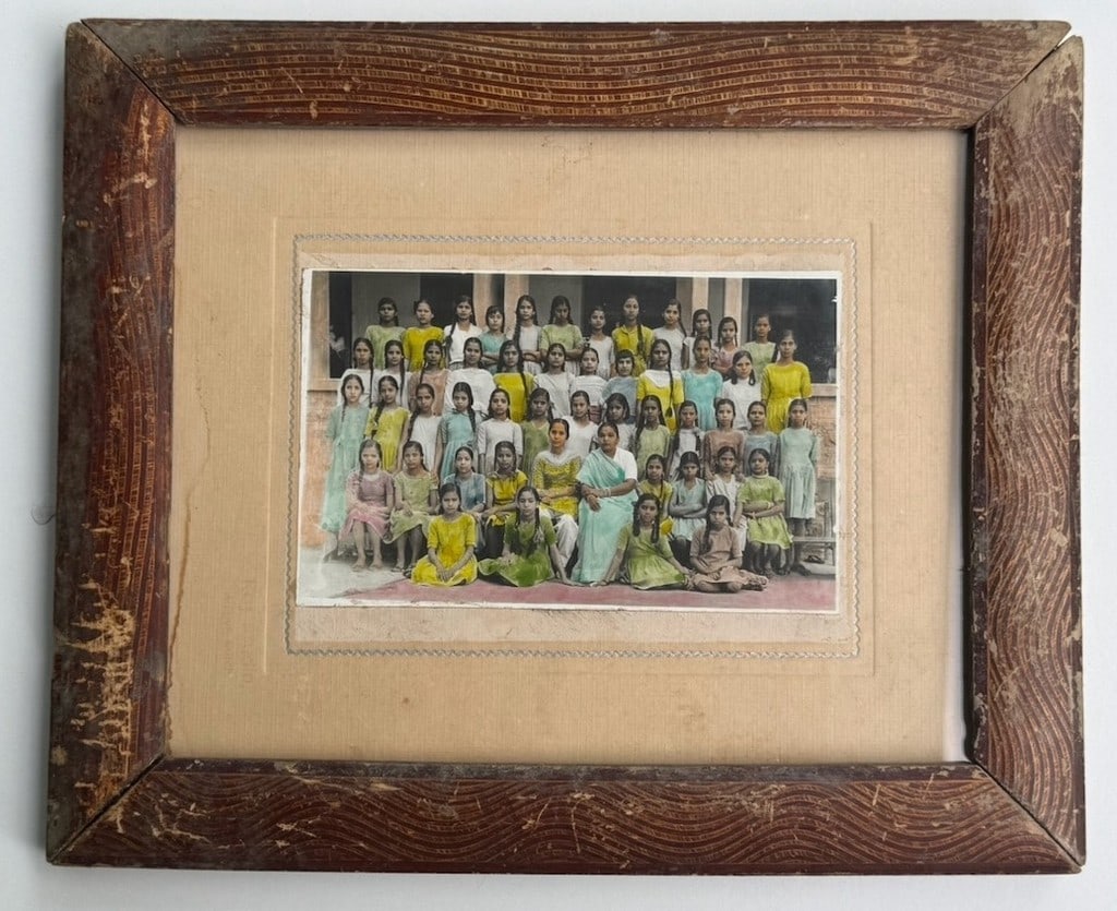 Hand-tinted gelatin silver photograph, circa 1940sâ€“50s - Group Portrait of a Girl: This vintage group portrait photograph features approximately 40 young women and two adult women in what appears to be a school or institutional setting. The print is delicately hand-coloured througho