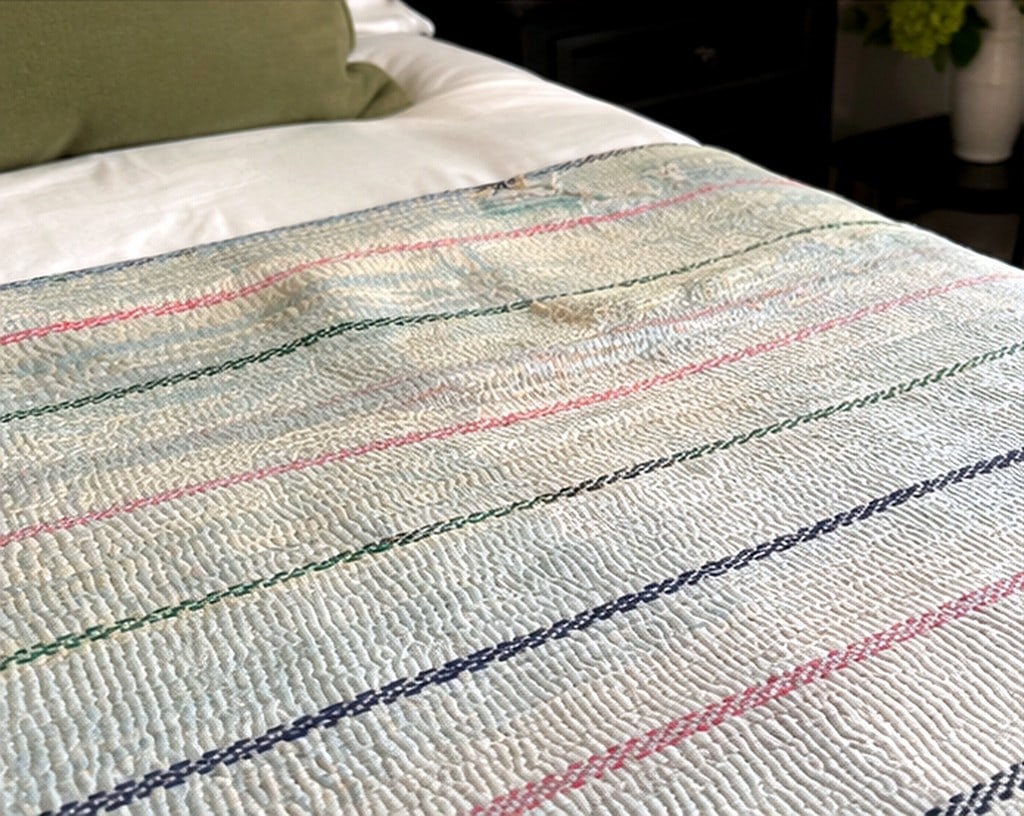 Hand-Stitched Reversible Dyed Kantha Throw with Patterns - 1 of 2.: Kantha throw crafted from recycled saris using traditional running-stitch embroidery. The fabric is dyed white to reveal the ghosted patterns and woven borders of the original saris, so delicate