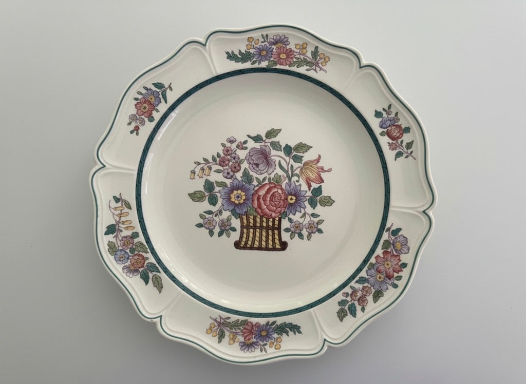 Wedgwood Etruria England Floral Pattern Scalloped Edge Plate: A charming ceramic plate from Wedgwood, Etruria, England, featuring a vibrant floral basket design in the center with additional floral sprays adorning the scalloped rim. The design includes various