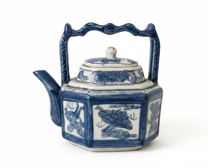 Blue and White Chinoiserie Hexagonal Teapot: An octagonal ceramic teapot, from a collection in the family for over sixty years, decorated in classic blue and white chinoiserie style. The teapot features a blue scrolled handle and spout, with a d
