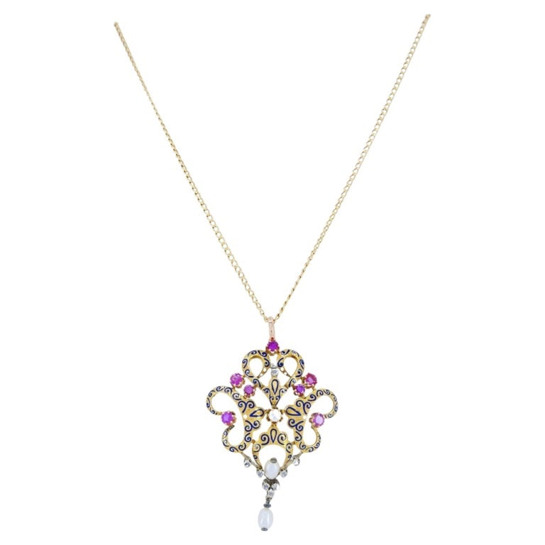 Late Victorian Renaissance Revival Enamel Ruby Diamond Pearl Pendant Necklace: Late Victorian 18k yellow gold enamel ruby diamond and pearl pendant necklace, designed in the Renaissance Revival style with an ornate openwork form. The pendant features blue enamel scrollwork over