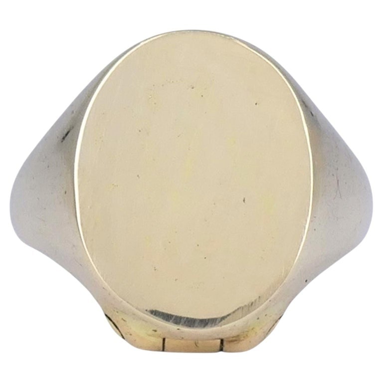 Antique 9ct Gold Watch Key Un-engraved Signet Ring: 9ct yellow gold watch key signet ring, designed with a plain oval signet face and a concealed hinged watch key fitting beneath the top. The ring has a smooth tapered shank and a classic signet