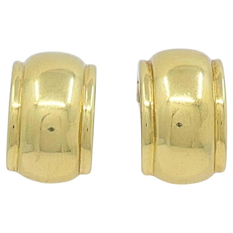 Tiffany & Co. 18k Gold Huggie Hoop Earrings: A pair of vintage Tiffany & Co. earrings crafted in 18k gold, made in Italy. The design features rounded huggie hoops with a clean, domed profile that sits close to the ear for an easy, everyday f