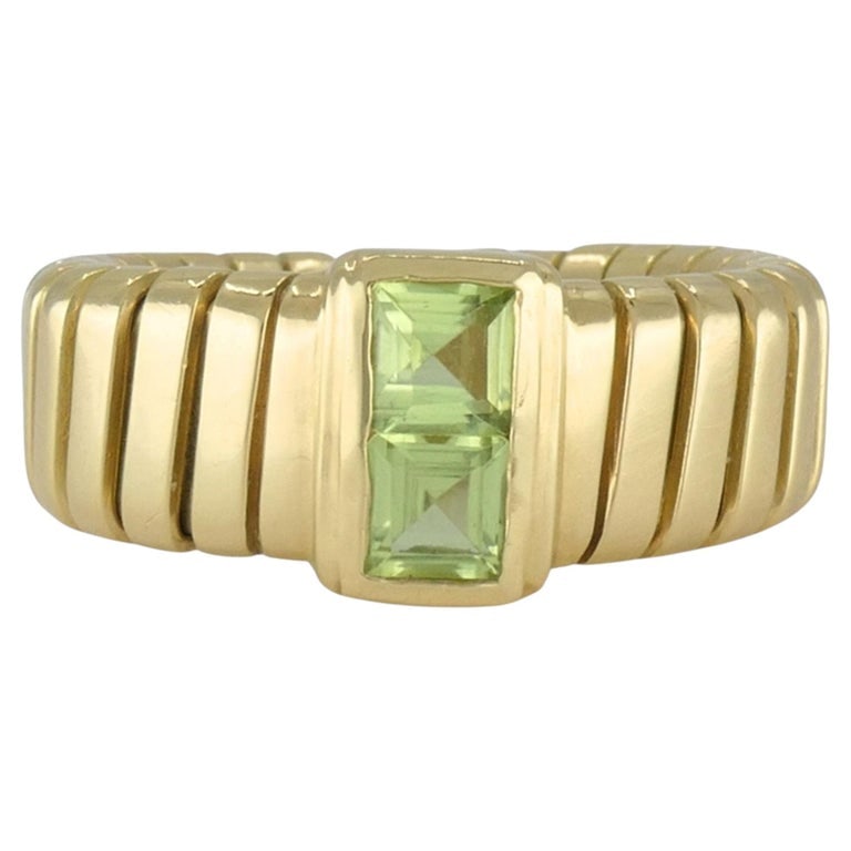 Vintage Bvlgari 18k Gold Tubogas Peridot Ring, circa 1990s: Bvlgari 18k yellow gold Tubogas ring, circa 1990s, designed with the maisonâ€™s famous flexible ribbed Tubogas construction and set with two square cut peridot gemstones at the center