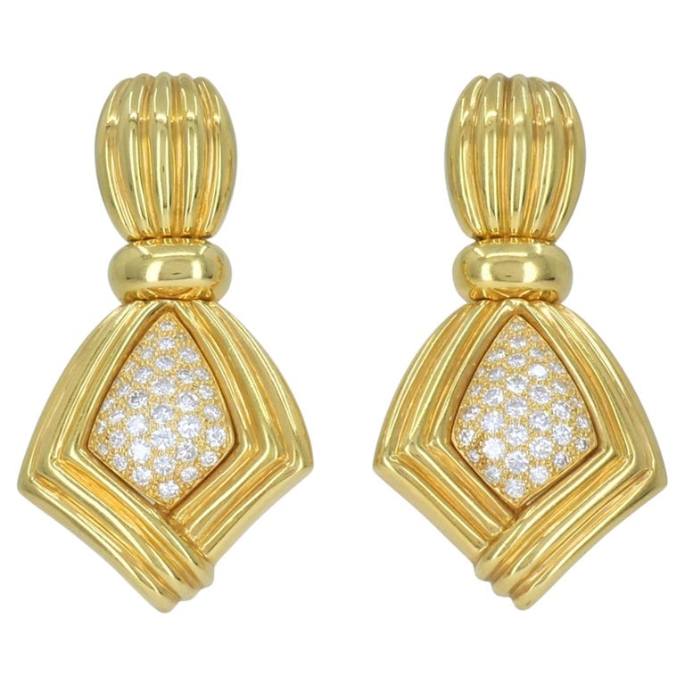 Vintage Boucheron Paris 18k Gold Diamond Ribbed Drop Earrings, Circa 1980s: Boucheron Paris 18k yellow gold and diamond clip earrings, circa 1980s, designed with a bold ribbed gold form and pavÃ© diamond centers. Each earring features a fluted oval top above a