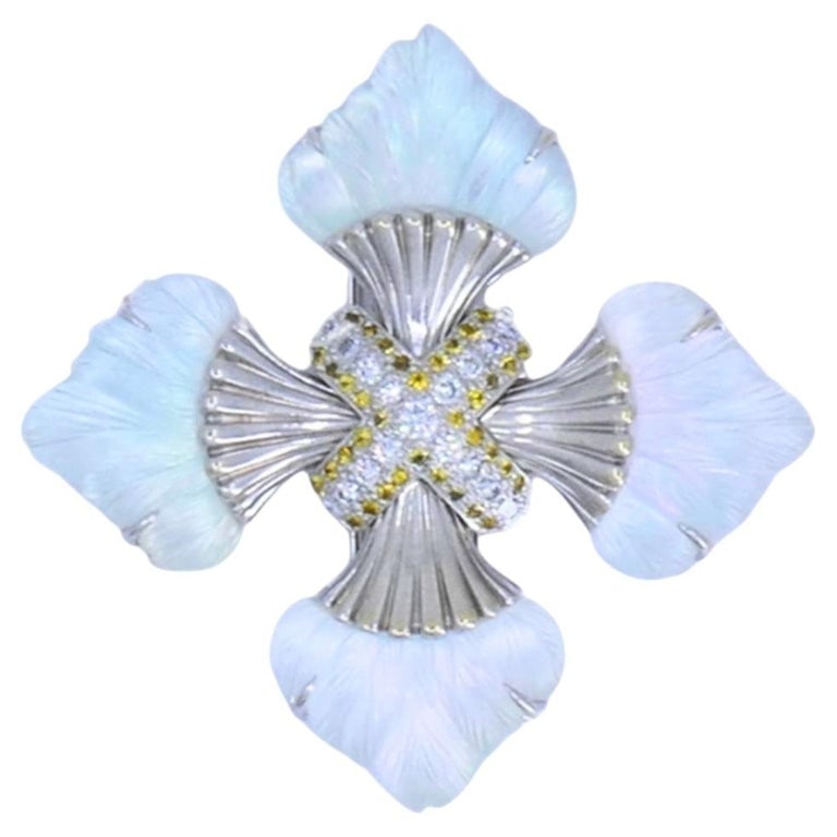 Seaman Schepps 18k Gold Diamond Maltese Cross Brooch Carved Rock Crystal Sapphir: A Seaman Schepps Maltese cross brooch, made of 18k white gold, with carved rock crystal panels forming each arm. The rock crystal is carefully carved with a feather-like texture that adds depth and