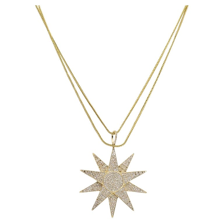 14k Gold Diamond Starburst Pendant Chain Necklace: This 14k yellow gold starburst pendant fully paved with round diamonds across ten pointed rays and a circular center. The diamond-set bail connects to a 14k gold franco chain. Viewed from the side,