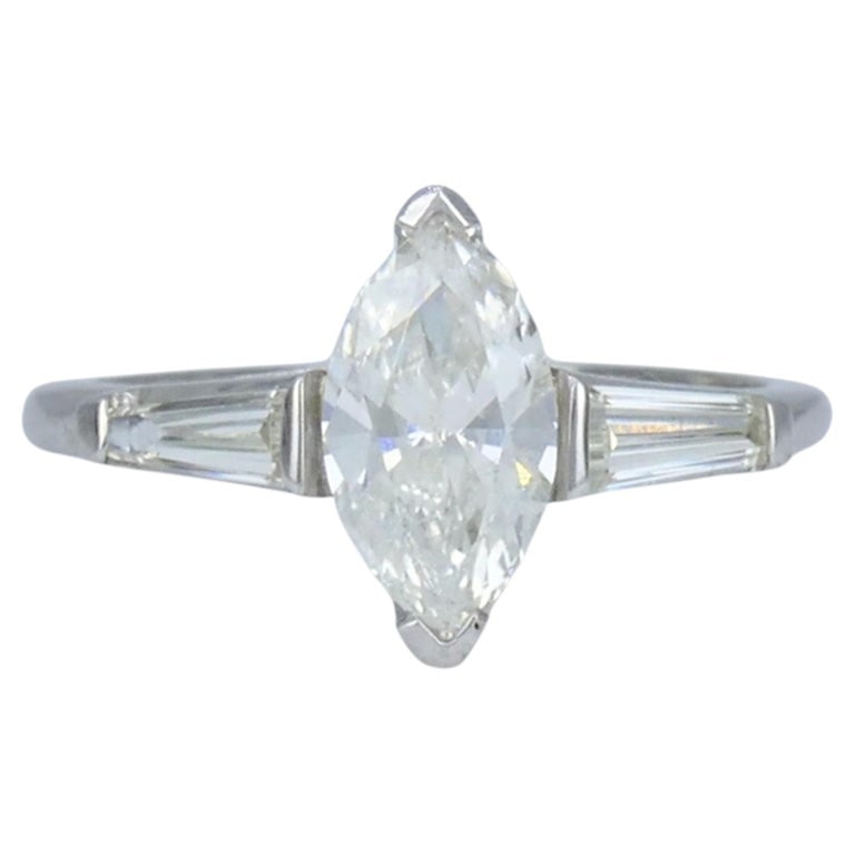 Vintage Platinum 1.07 Carat Marquise Diamond Three Stone Ring: Platinum marquise diamond ring, circa 1980s, designed with a 1.07 carat marquise cut center diamond accented by tapered baguette diamond side stones. The elongated center diamond is set in a classic