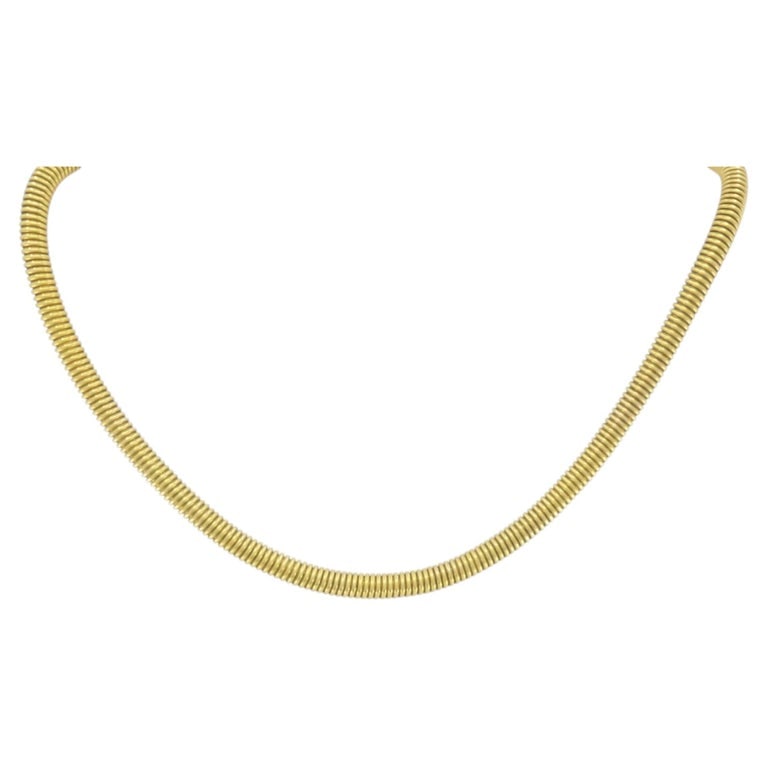 Vintage French 18k Gold Tubogas Coil Necklace: A vintage French tubogasâ€‘style coil necklace with a tightly wrapped serpentine construction that runs in a continuous line around the neck. The ribbed coil design gives the piece a