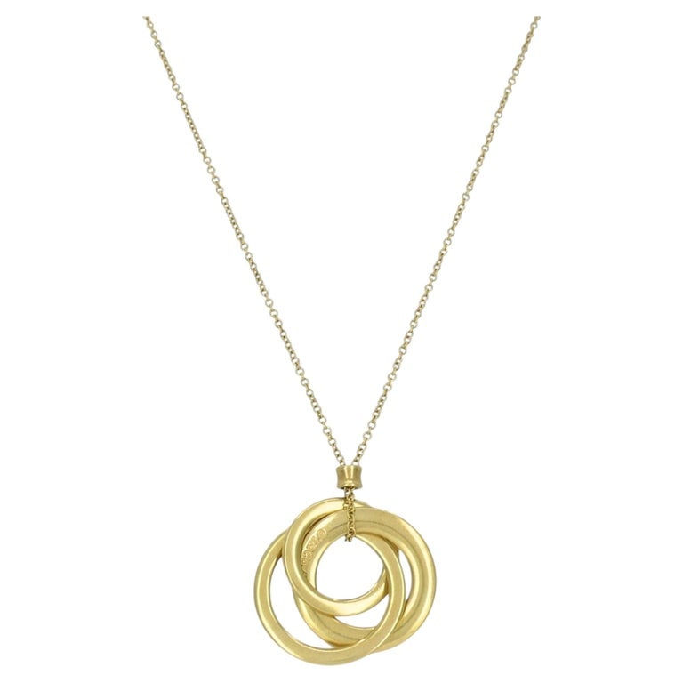 Tiffany & Co. 1837 Triple Interlocking Circles Pendant 18K Yellow Gold: Tiffany & Co. 18k yellow gold triple interlocking circles necklace featuring three graduated circular rings suspended in a layered, intertwined arrangement. The design reflects Tiffanyâ€