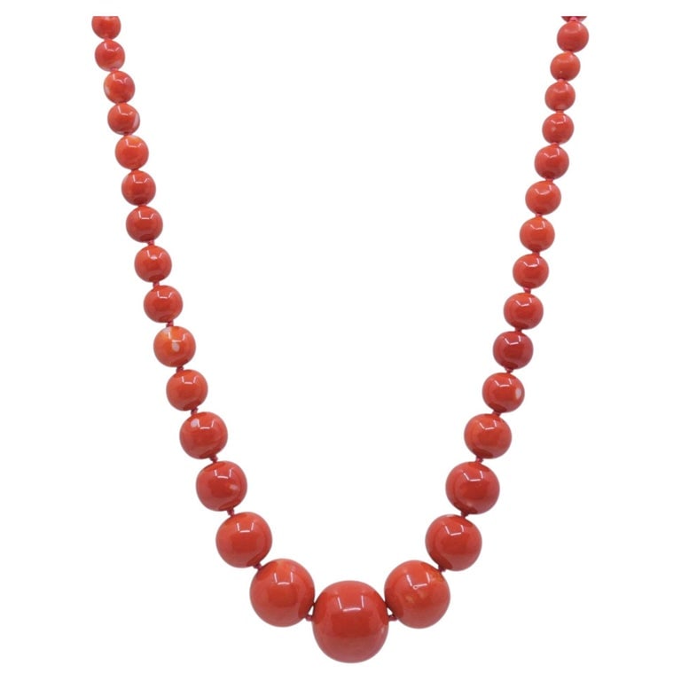 Vintage Graduated Red Coral Bead Necklace 14k Gold Diamond Rose Clasp: A vintage graduated red coral bead necklace strung on knotted silk cord with a 14k gold rose-form clasp set with a small diamond. The beads move from a large center bead down to smaller beads at each 