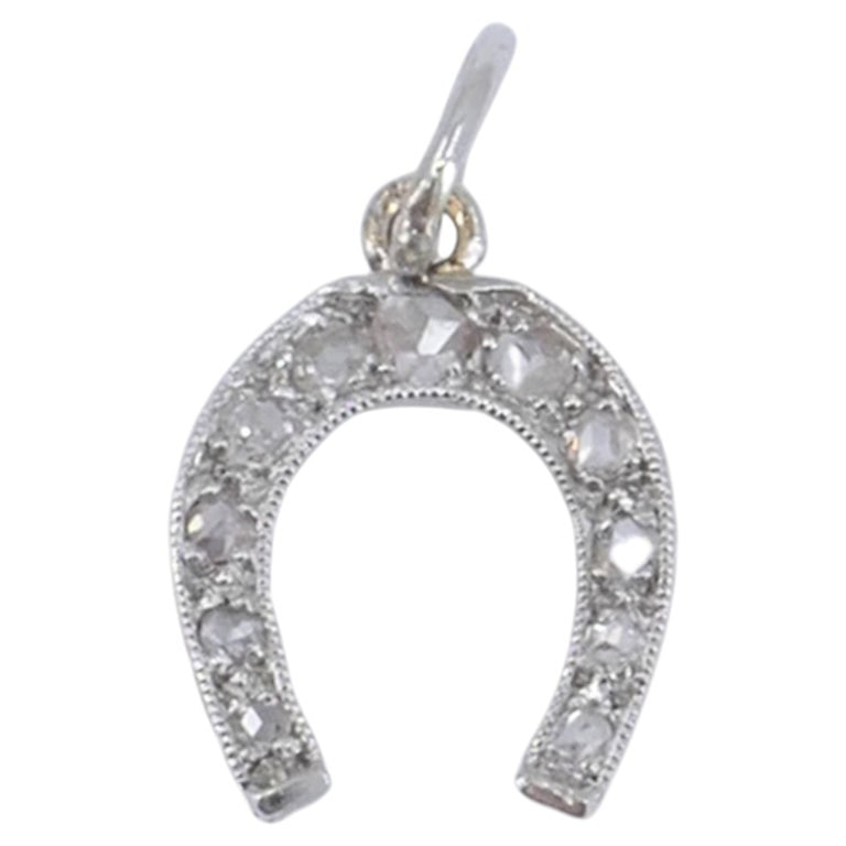 Edwardian Platinum Rose Cut Diamond Horseshoe Pendant: This antique platinum rose cut diamond horseshoe charm dates to the Edwardian period, circa 1910 to 1920. The design features a classic horseshoe motif, a symbol historically associated with luck and