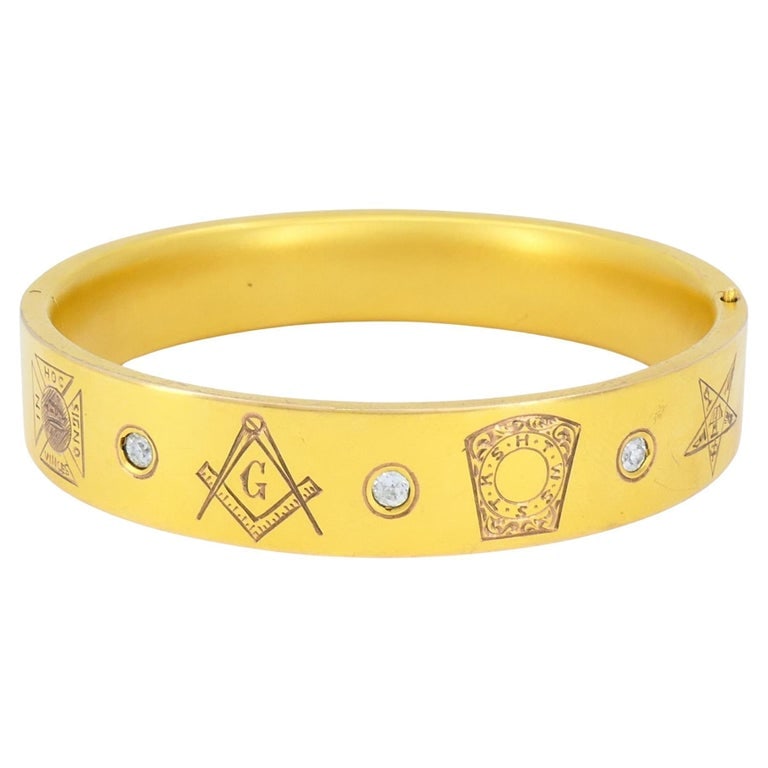 Vintage 10k Gold Masonic Diamond Bracelet Freemason Hinged Bangle: This vintage Masonic 10k yellow gold diamond bracelet, dating to the mid 20th century circa 1950sâ€“1960s, features a wide hinged bangle design engraved with traditional Freemason and