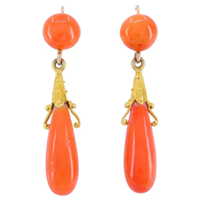 Victorian French 18k Yellow Gold Coral Drop Earrings: These antique French 18k gold coral drop earrings feature a classic Victorian design centered around natural Mediterranean coral. Each earring begins with a polished coral cabochon stud that suspends 