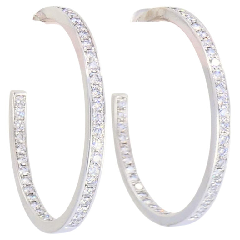 Vintage Cartier Hoop Earrings 18k Gold Diamond Earrings: A pair of vintage Cartier hoop earrings, crafted in 18k white gold. The earrings are fully set with diamonds along both the outside front and the inside back of each hoop. The inside-outside setting a