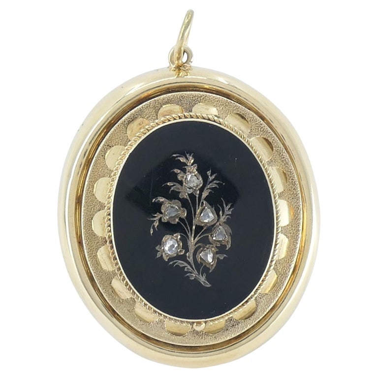 Victorian 14k Gold Enamel Rose Cut Diamond Pendant: This Victorian era 14k yellow gold enamel and diamond pendant dates to the late 19th century, circa 1880s to 1900. The front features a black enamel ground accented with a delicate floral motif set wi