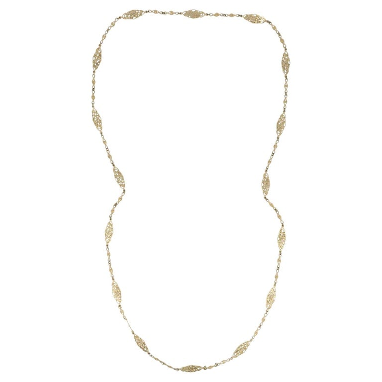 Vintage 14K Gold Openwork Filigree Marquise Long Chain Necklace, 1970s: 14K gold long chain necklace dating to the 1970s. The design features repeating openwork marquise shaped stations with a pierced, lace like pattern, each section connected by small textured links