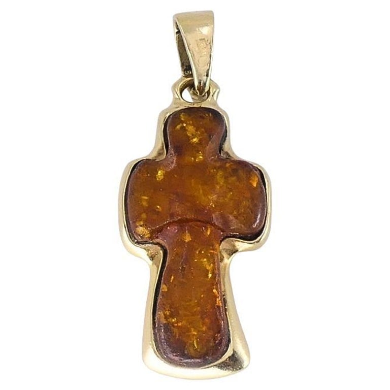 Vintage 14k Gold Baltic Amber Cross Pendant: This vintage 14k gold cross pendant features a solid piece of honey Baltic amber with natural internal inclusions, giving the stone a warm, organic look. The amber is cut in a soft cross shape and