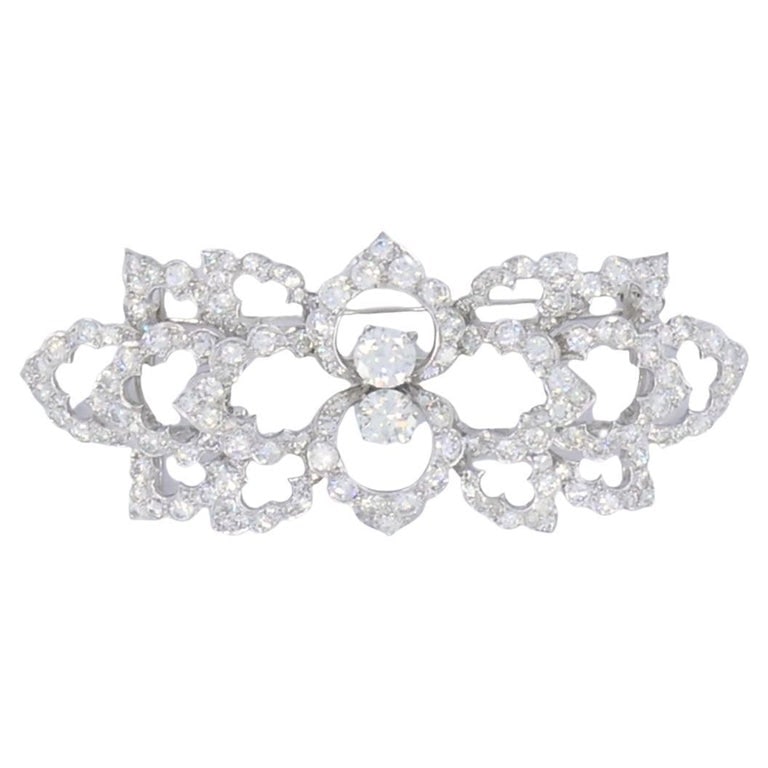 David Webb Diamond Platinum Brooch Floral Design: This vintage David Webb brooch is a refined example of the designerâ€™s work in platinum and diamonds. The piece features an openwork layout built around botanical motifs, giving the 