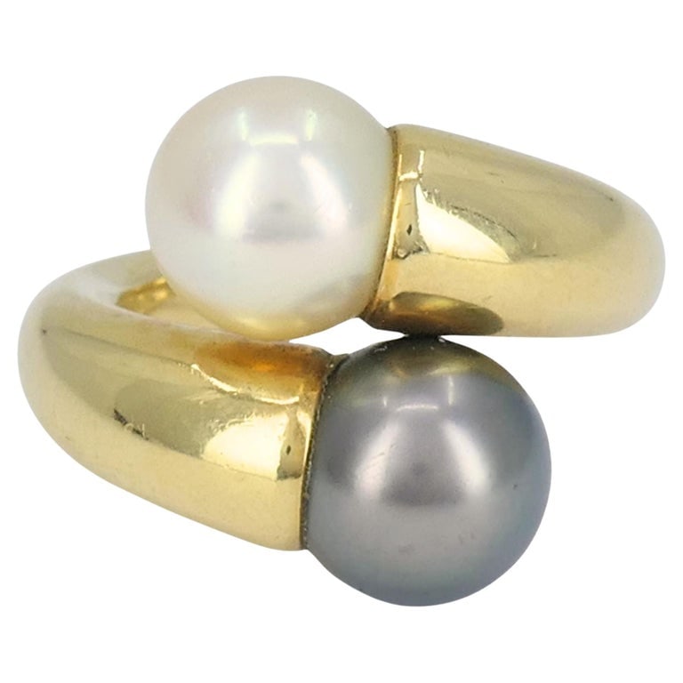 Vintage Cartier Toi et Moi 18k Gold Pearl Bypass Ring: This Cartier ring from 1996 is a sculptural and refined design crafted in 18k yellow gold, showcasing two beautifully matched cultured pearls in luminous contrasting tones. The polished gold curves fl